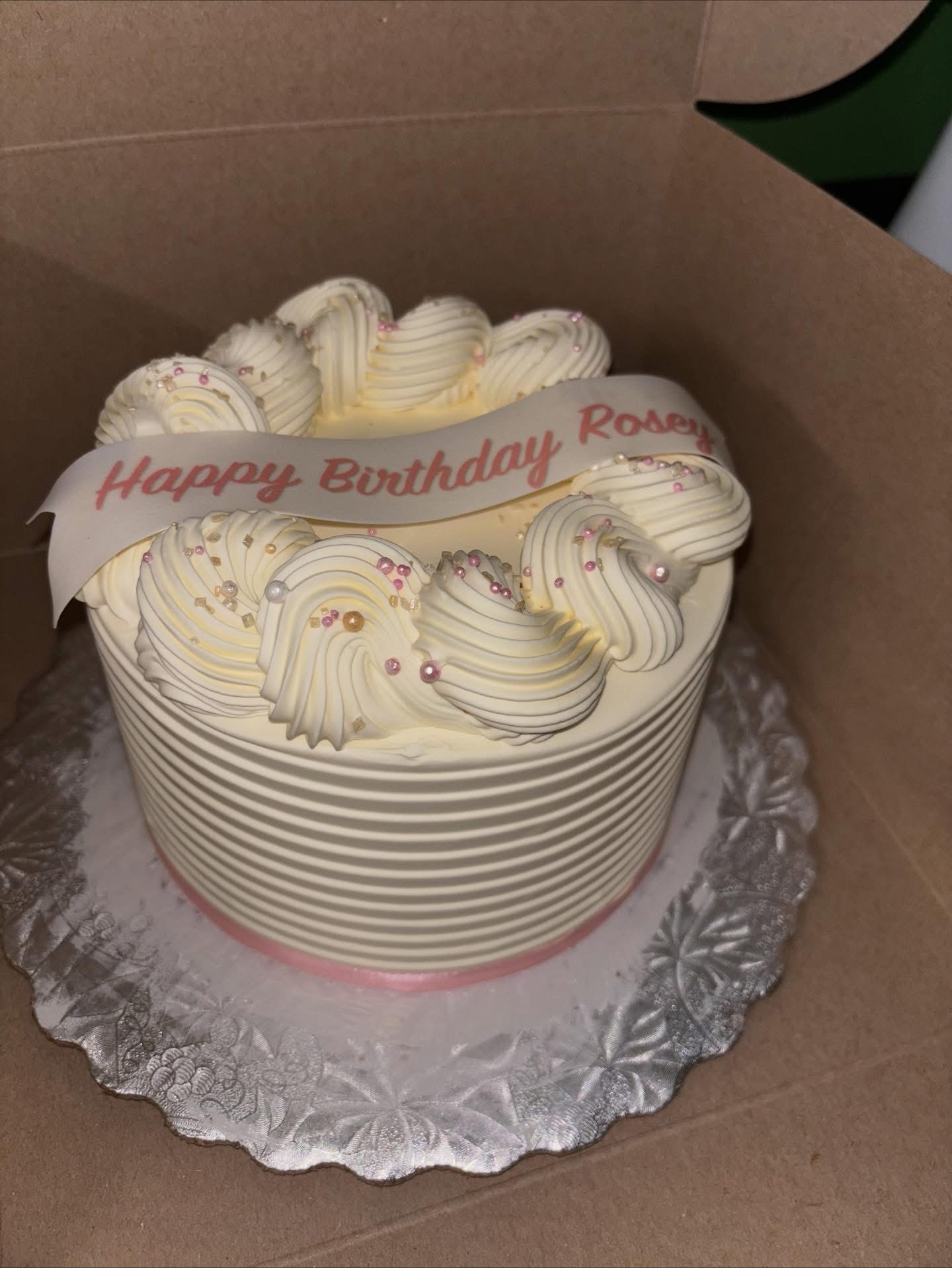 Cream birthday cake with pink ribbon